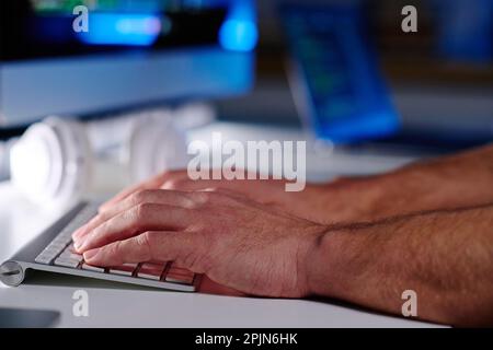 Konzentrieren Sie sich auf die Hände eines leitenden IT-Managers, der am Arbeitsplatz die Tasten der Computertastatur drückt und Daten vernetzt oder decodiert Stockfoto