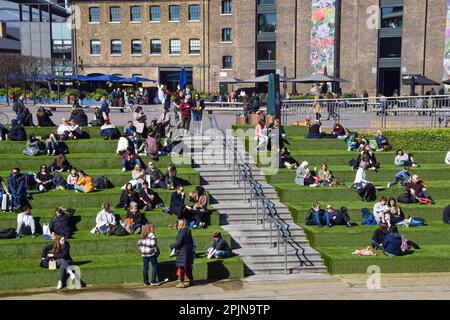 London, Großbritannien. 3. April 2023 Die Menschen genießen den Sonnenschein auf dem künstlichen Gras am Granary Square in King's Cross, wenn das Frühlingswetter in der Hauptstadt eintrifft. Kredit: Vuk Valcic/Alamy Live News Stockfoto