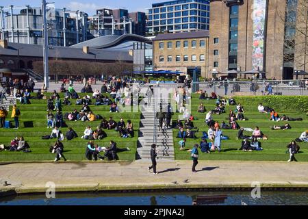 London, Großbritannien. 3. April 2023 Die Menschen genießen den Sonnenschein auf dem künstlichen Gras am Granary Square in King's Cross, wenn das Frühlingswetter in der Hauptstadt eintrifft. Kredit: Vuk Valcic/Alamy Live News Stockfoto