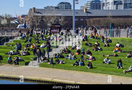 London, Großbritannien. 3. April 2023 Die Menschen genießen den Sonnenschein auf dem künstlichen Gras am Granary Square in King's Cross, wenn das Frühlingswetter in der Hauptstadt eintrifft. Kredit: Vuk Valcic/Alamy Live News Stockfoto