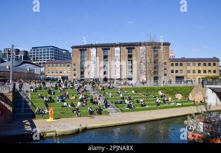 London, Großbritannien. 3. April 2023 Die Menschen genießen den Sonnenschein auf dem künstlichen Gras am Granary Square in King's Cross, wenn das Frühlingswetter in der Hauptstadt eintrifft. Kredit: Vuk Valcic/Alamy Live News Stockfoto