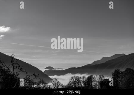 Bergblick über den Luganer See mit Wolkenlandschaft und Sonnenlicht und klarem Himmel in Lugano, Tessin in der Schweiz. Stockfoto