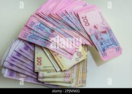 Papiergeld verschiedene Stückelungen, ukrainische Hrywna in Stückelungen 50.100, 200 Hrywna, neues Geld, Hintergrund mit verstreuten Banknoten. Stockfoto