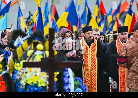 3. April 2023, Lemberg, Region Lemberg, Ukraine: Lubomyr Senivs Mutter weint auf das Grab seines Sohnes. Trauerfeier von Lubomyr Seniv inmitten der russischen Invasion der Ukraine in der Kirche St. Peter und Paul Garrison in Lemberg, Westukraine. Lubomyr war ein ukrainischer Soldat, der am 27. März 2023 im Kampf mit russischen Truppen getötet wurde. (Kreditbild: © Adrien Fillon/ZUMA Press Wire) NUR REDAKTIONELLE VERWENDUNG! Nicht für den kommerziellen GEBRAUCH! Stockfoto