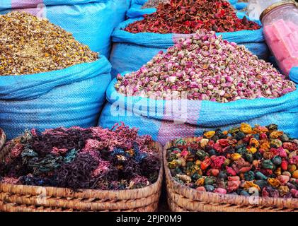 Stapel getrockneter Rosen und anderer Blumen, die als natürliche Düfte verwendet werden, werden auf dem Souk - dem traditionellen Straßenmarkt in Marokko - präsentiert Stockfoto