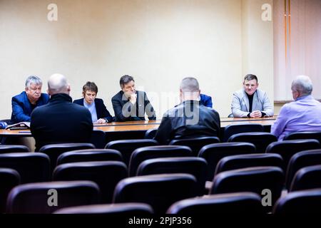 03. April 2023, Ukraine, Slawutytsch: Robert Habeck (Bündnis 90/die Grünen, M), Bundesminister für Wirtschaft und Klimaschutz, neben Waleri Sejda (l), Leiter des Kernkraftwerks Tschernobyl, Und Jurij Fomitschow (r), Bürgermeister der Gemeinde Slawutytsch, trifft Angestellte, die die russische Besetzung des Kernkraftwerks Tschernobyl bei einem Besuch des staatlichen Unternehmens „Kernkraftwerk Tschernobyl“ erlebt haben. Die Kleinstadt wurde Ende der 1980er Jahre nach dem Kernkraftwerk Tschernobyl (NPP) GAU fast 45 Kilometer östlich wieder aufgebaut. Die Stadt diente als neues h Stockfoto