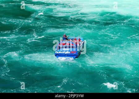 Schnellboot in türkisfarbenem Wasser unterhalb der Hula Falls in Neuseeland Stockfoto