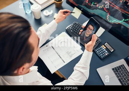 Geschäftsmann, der Aktien online handelt. Der Aktieninvestor diskutiert Zahlen in Diagrammen, während er mit seinem Kollegen ein Videogespräch führt. Geschäftsteams planen und Stockfoto