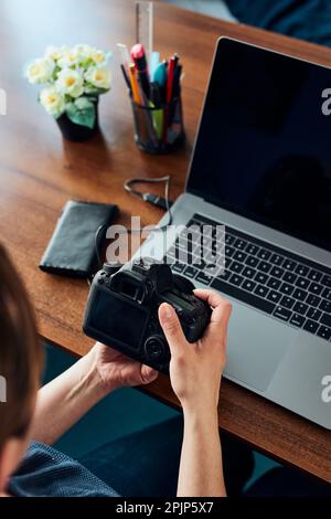 Fotografin arbeitet an Fotos auf Laptop und Kamera. Frau Bearbeitung Retusche durchsuchen Fotos arbeiten als freiberufliche am Schreibtisch sitzen Stockfoto