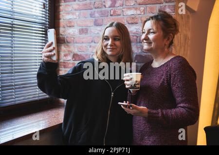 Frauen, die Videoanruf auf dem Mobiltelefon tätigen. Selfie-Fotos mit dem Smartphone aufnehmen. Remote-Verbindung mit Familie und Freunden Stockfoto