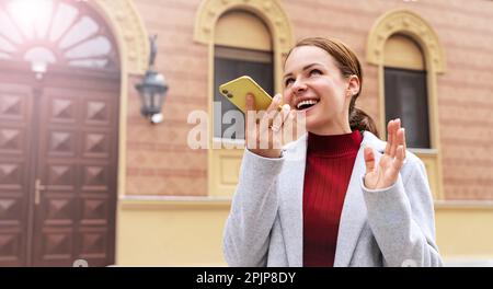 Brünette Frau nimmt Sprachnachricht mit ihrem Smartphone auf. Stockfoto