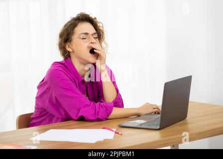 Schläfrige Freiberuflerin Gähnt Am Arbeitsplatz Im Home Office, Stockfoto
