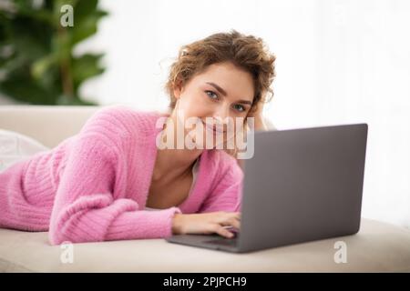 Nahaufnahme Der Schönen Jungen Frau, Die Sich Zu Hause Mit Dem Laptop Entspannt Stockfoto