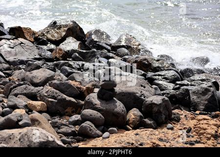 Gestapelte Steine am Strand. Lanzarote. Februar 2023. Stockfoto