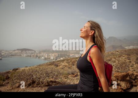 Eine Wanderin entspannt sich, indem sie auf einer Wanderung frische Luft atmet, Naturliebhaber. Stockfoto