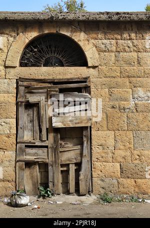 Eine Holztür mit vielen Fensterscheiben und einem Bogen darüber, typische libanesische architektonische Details. Stockfoto