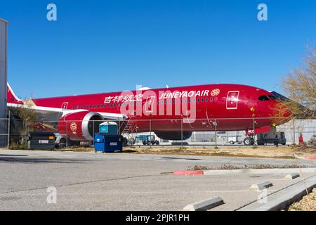 Victorville, CA, USA – 25. März 2023: Ein rotes Juneyao Airline Jet-Flugzeug parkt in einem Lagerplatz am Southern California Logistics Airport in Vic Stockfoto