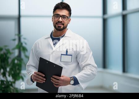 Erfahrener Arzt mit einem Ordner in den Händen Stockfoto