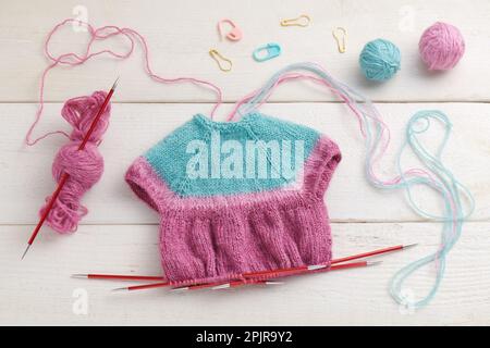 Das Stricken eines Puppenkleids auf Stricknadeln, Strickzubehör Stockfoto