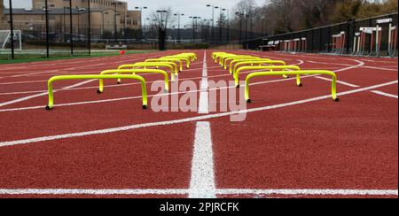 Zwei Reihen gelber sechs Zoll Hürden, die U in Fahrspuren auf einem Gleis setzen. Stockfoto