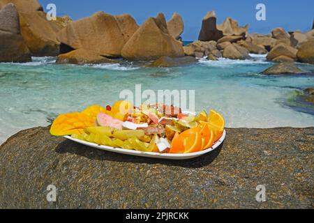 Teller mit exotischen Früchten, Traumstrand Anse Marron, auch La Source Marron, La Digue Island, Seychellen Stockfoto