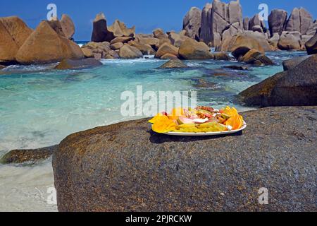 Teller mit exotischen Früchten, Traumstrand Anse Marron, auch La Source Marron, La Digue Island, Seychellen, Afrika Stockfoto