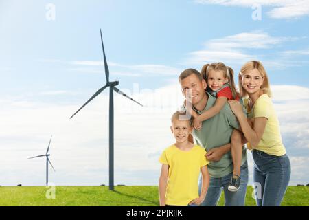 Glückliche Familie mit Kindern und Blick auf Windenergieturbinen Stockfoto