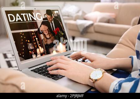 Frau besucht Dating-Seite über Laptop drinnen, Nahaufnahme Stockfoto