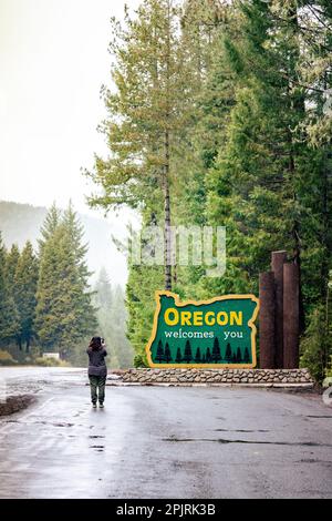 Das vertikale Bild einer Frau, die Oregon fotografiert, begrüßt Sie am Redwood Highway. Stockfoto