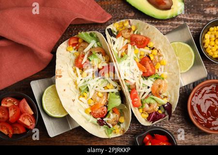 Köstliche Tacos mit Garnelen und Käse, serviert auf einem Holztisch, flach liegend Stockfoto