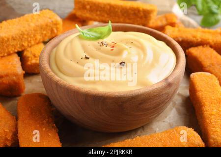 Köstliche Chicken Nuggets und Käsesauce mit Basilikum auf dem Tisch, Nahaufnahme Stockfoto