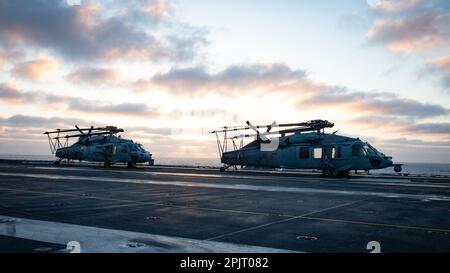 230402-N-TD381-1195 PAZIFIK (02. April 2023) zwei MH-60s Sea Hawk, die den „Schwarzen Rittern“ des Helicopter Sea Combat Squadron (HSC) 4 zugeteilt sind, werden auf dem Cockpit an Bord des Flugzeugträgers USS Carl Vinson (CVN 70) der Nimitz-Klasse kreidet und angekettet. Vinson führt derzeit eine Zertifizierung für die Verfügbarkeit von Schulungen für maßgeschneiderte Schiffe/Probleme bei der abschließenden Bewertung durch. (USA Marinefoto von Mass Communication Specialist 3. Class Isaiah B. Goessl) Stockfoto