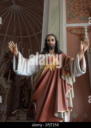 Nahaufnahme einer Statue des wiederauferstandenen Jesus Christus mit einem Heiligen Herz und Handwunden im St. Johannes der Baptisten Deutsche Katholische Kirche in Ammanns Stockfoto