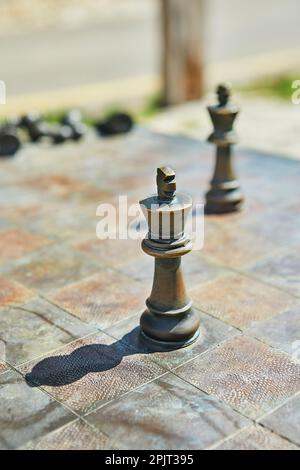 Schachfiguren aus Metall auf einem Schachbrett aus Metall Stockfoto