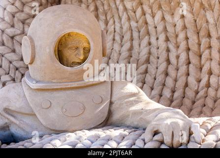 PRODUKTION - 03. April 2023, Mecklenburg-Vorpommern, Warnemünde: Ein Taucher aus Sand, der vom Sandkünstler Andrius Petkus aus Litauen entwickelt wurde. Sechs Künstler aus fünf Ländern kreieren die Figuren für die 13. Sand World aus 300 Tonnen Spezialsand direkt am Meereskanal in Warnemünde. Unter dem Motto „Metamorphose - Blown by the (Baltic) Wind“ werden bis zum 06. April 2023 verschiedene Motive rund um das Thema Meer geschaffen. Die Show wird bis zum 29. Oktober 2023 ausgestellt. Foto: Jens Büttner/dpa Stockfoto