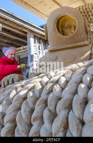 PRODUKTION - 03. April 2023, Mecklenburg-Vorpommern, Warnemünde: Sandkünstler Andrius Petkus aus Litauen arbeitet mit einem Taucher an einer großen Sandskulptur. Sechs Künstler aus fünf Ländern kreieren die Figuren für die 13. Sand World aus 300 Tonnen Spezialsand direkt am Meereskanal in Warnemünde. Unter dem Motto „Metamorphose - Blown by the (Baltic) Wind“ werden bis zum 06. April 2023 verschiedene Motive rund um das Thema Meer geschaffen. Die Show wird bis zum 29. Oktober 2023 ausgestellt. Foto: Jens Büttner/dpa Stockfoto