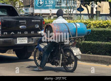SAMUT PRAKAN, THAILAND, JANUAR 21 2023, Ein Mann transportiert eine große Gasflasche auf einem Motorrad Stockfoto