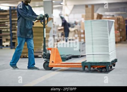 Die Bestellung pünktlich abzugeben. Zugeschnittenes Bild eines Mannes, der einen Stapel Papier in einer Fabrik transportiert. Stockfoto