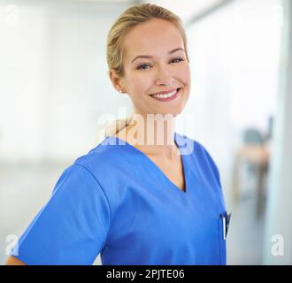 Der Gesundheit gewidmet. Porträt eines selbstbewussten jungen Arztes mit blauen Kittel. Stockfoto