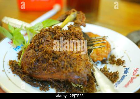 Gebratene Ente mit einem Streusel Serdeng und Basilikum aus Madura, Indonesien. Lebensmittelfotografie. Stockfoto