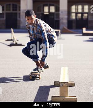 Die Hölle zeigt dir, wie es gemacht wird. Ein junger Mann, der in einem Skatepark Skateboarden fährt. Stockfoto
