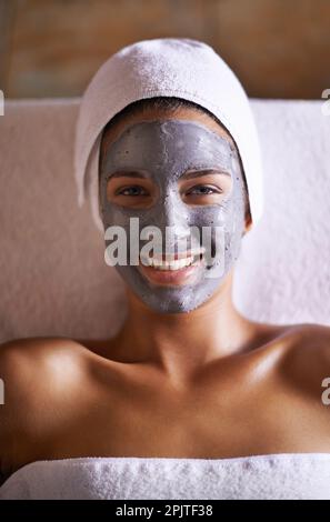 Auf dem Weg zu glatter, seidiger Haut. Eine schöne junge Frau, die sich während einer Gesichtsbehandlung entspannt. Stockfoto