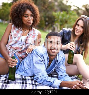 Eine schöne Zeit mit Freunden im Park. Eine Gruppe junger Freunde, die ein Picknick im Park genießen. Stockfoto