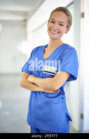 Ich liebe meinen Job. Porträt eines selbstbewussten jungen Arztes mit blauen Kittel. Stockfoto