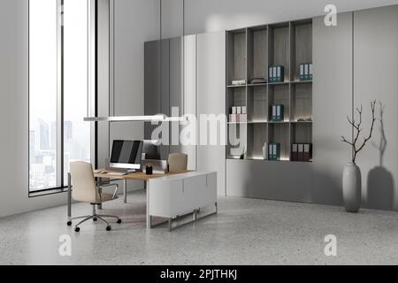 Gemütliche Büroeinrichtung mit Sesseln und pc-Computer auf dem Schreibtisch, Regal mit seitlichem Blick und Ordnern und minimalistischer Dekoration. Coworking Corner mit Panoramablick w Stockfoto
