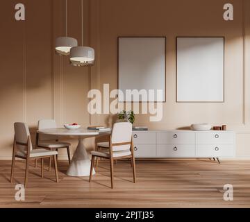 Beige Wohnzimmereinrichtung mit Esstisch und Sesseln, weißer Kommode und stilvoller Kunstdekoration. Zwei Poster aus Leinwand in Reihe. Stockfoto