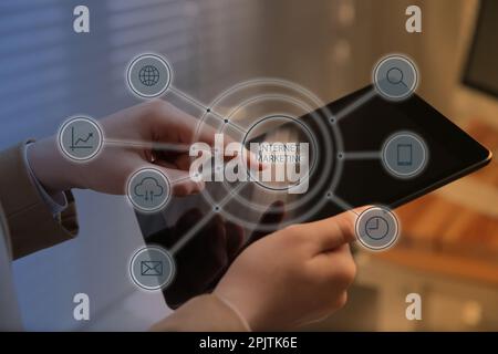 Internet-Marketing. Verschiedene virtuelle Ikonen und Geschäftsfrau, die ein modernes Tablet im Büro oder in der Nahaufnahme verwendet Stockfoto