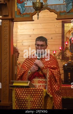 1. April 2023, Lemberg, Ukraine: Der Priester führt die Liturgie bei der Gedenkfeier in der Kirche durch. Yurii Ruf war Schriftsteller, öffentliche Figur, Patriot der Ukraine und eine bekannte Person in Lemberg und der Ukraine. Er organisierte viele Veranstaltungen, ein Festival usw. Als der Krieg begann, ging er als Freiwilliger an die Front und wurde bei einer Kampfmission in der Region Luhansk am 1. April 2022 getötet. Das Ereignis auf den Fotos ist das Gedenken an Jurij in der Kirche und auf dem Feld der ehrenvollen Beerdigungen auf dem Friedhof Lychakivskyi in Lemberg am ersten Jahrestag seines Todes. Verwandte, Freunde und Wohnsitz Stockfoto