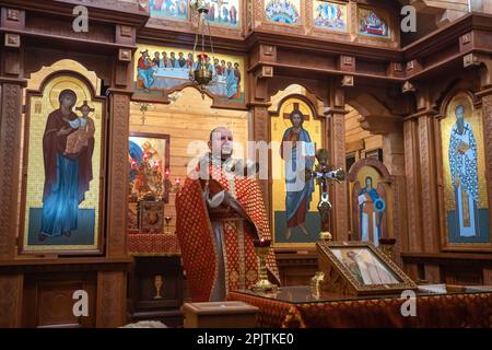 1. April 2023, Lemberg, Ukraine: Der Priester führt die Liturgie bei der Gedenkfeier in der Kirche durch. Yurii Ruf war Schriftsteller, öffentliche Figur, Patriot der Ukraine und eine bekannte Person in Lemberg und der Ukraine. Er organisierte viele Veranstaltungen, ein Festival usw. Als der Krieg begann, ging er als Freiwilliger an die Front und wurde bei einer Kampfmission in der Region Luhansk am 1. April 2022 getötet. Das Ereignis auf den Fotos ist das Gedenken an Jurij in der Kirche und auf dem Feld der ehrenvollen Beerdigungen auf dem Friedhof Lychakivskyi in Lemberg am ersten Jahrestag seines Todes. Verwandte, Freunde und Wohnsitz Stockfoto