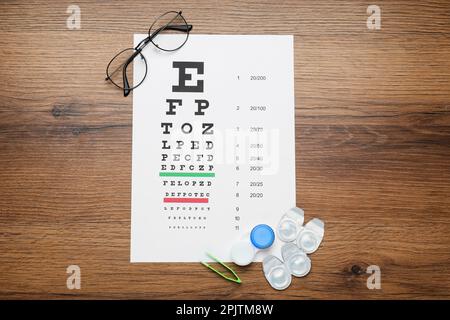 Flache Liegezusammensetzung mit Kontaktlinsen auf Holztisch Stockfoto